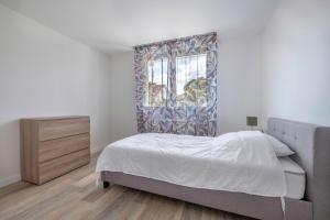 a bedroom with a bed and a dresser and a window at Maison pour 6 à 950m du bord de mer à St Brevin in Le Plessis