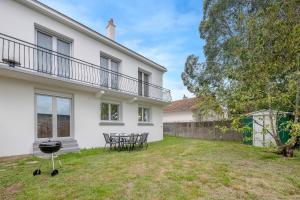 a yard with chairs and a grill in front of a house at Maison pour 6 à 950m du bord de mer à St Brevin in Le Plessis