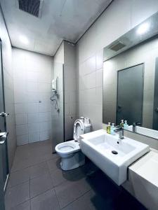 シャー・アラムにあるFirst Residence at i-City Shah Alamの洗面台、トイレ、鏡のあるバスルーム