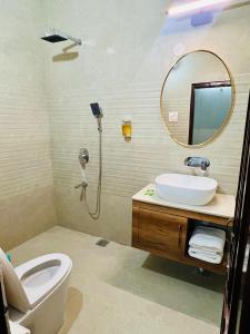 a bathroom with a toilet and a sink and a mirror at Hotel temple view inn in Anandpur Sāhib