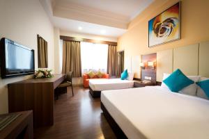 a hotel room with two beds and a flat screen tv at Hotel Sentral Johor Bahru @ Woodland Causeway in Johor Bahru