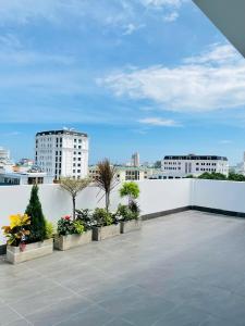 a balcony with a white fence and some plants at BRIO Urbano Apartment in Da Nang