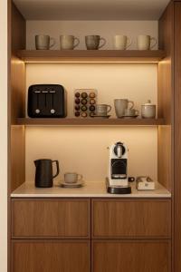 a kitchen with a coffee maker and a toaster on a shelf at Nomade Villas in Agios Ioannis Peristeron