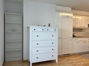 a kitchen with white cabinets and a white dresser at Studio avec accès direct au lac de Geneve in Saint-Gingolph