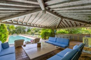 een patio met blauwe meubels en een zwembad bij Villa Federica 17 in Manciano