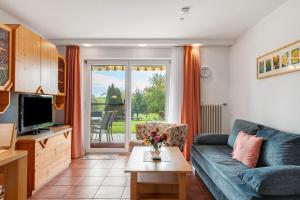 a living room with a couch and a tv at Ferienwohnungen Tröndle in Weilheim