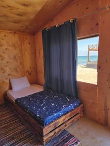 a bed in a wooden room with a window at Southern spirit in Nuweiba +37 photos