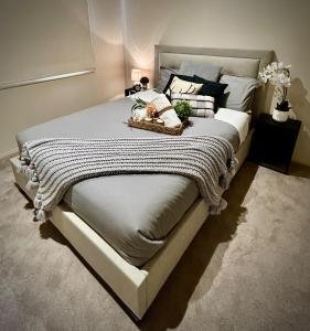 una camera da letto con un grande letto bianco con un cesto di Sanctuary Lakes Luxe Private Villa - Where Golf Meets Grandeur - Only 20km from Melbourne City a Point Cook Altre 34 foto