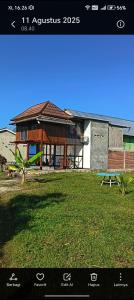 a picture of a house with a bench in a yard at Satera Homestay in Seteluk