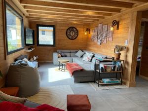 a living room with a couch and a clock at La Biche in Saint-Martin-sur-le-Chambre
