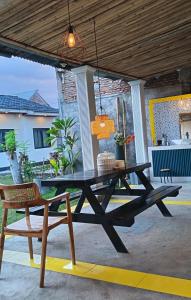 a picnic table and a chair on a patio at Satera Homestay in Seteluk