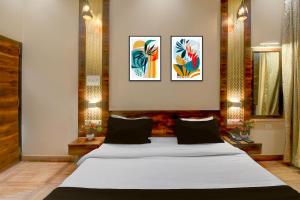 a bedroom with a white bed with three pictures on the wall at Townhouse Punnami Riverview Formerly Vihaan Square in Jaipur