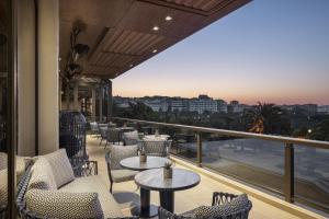 イスタンブールにあるヒルトン イスタンブル ボスポラスのテーブルと椅子があり、街の景色が見えるバルコニー