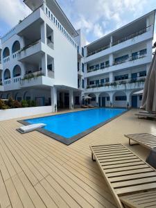 a large building with a swimming pool in front of it at Sunset Paradise Canggu in Canggu