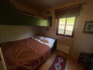 a small bedroom with a bed and a window at Nice And Central With Terrace in Beitostøl