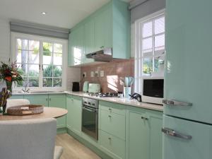 a kitchen with mint green cabinets and a table at Sanddrif Stellenbosch Guest Farm in Stellenbosch