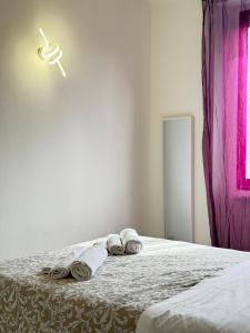 Un dormitorio con una cama con toallas. en Navigli Home Metro4-Tram2-Naviglio Grande, en Milán