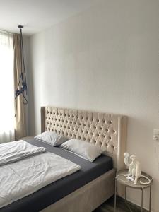 una camera con un grande letto con testiera imbottita di Moderne und stilvolle Wohnung direkt am Teich ad Altenburg