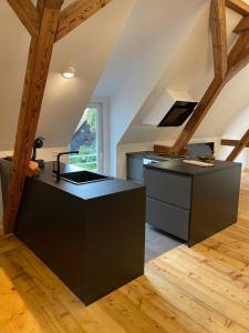 una cocina con encimeras negras y fregadero en Schwarzwald Loft im Grünen, en Freudenstadt