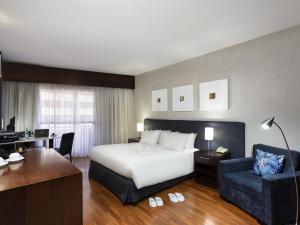 a hotel room with a bed and a desk at Mercure Sao Paulo Grand Plaza Paulista in Sao Paulo