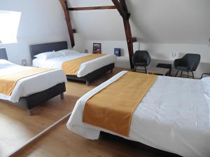 Zimmer mit 2 Betten und 2 Stühlen in der Unterkunft Les Chambres Du Circuit in Laigné-en-Belin
