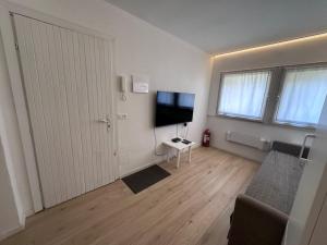 Una sala de estar vacía con un televisor y una puerta. en White Apartment, en Peio Fonti