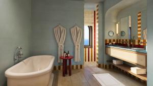 a bathroom with a tub and a sink and a bath tub at Zannier Bendor in Bandol