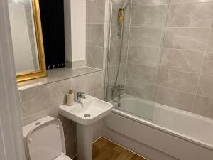 a bathroom with a sink and a toilet and a shower at 4Bed House - Direct links into Central London in North Ockendon +6 photos