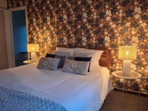 une chambre avec un lit avec deux tables et deux lampes dans l'établissement Les mésanges bleu, à Malmedy