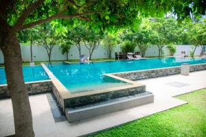 a large swimming pool with blue water and trees at Even Beach Oasis in Wayikkal