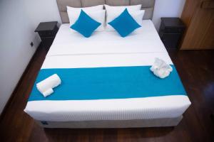 a bedroom with a bed with blue and white pillows at Even Beach Oasis in Wayikkal +47 photos