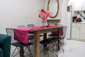 a dining room table with a vase of flowers on it at Villa Eleni Holidays Resort - with Pool near the Beach in Sidari