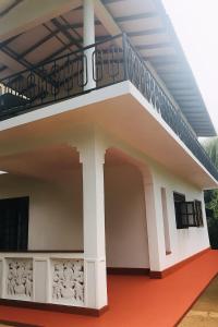 una casa con un balcón con una escalera en él en Indeewaree Villa, en Kamburugamuwa
