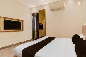 a bedroom with a bed and a tv on the wall at Collection O B.R. Ambedkar Park Taramandal Formerly Shree Krishna Inn in Gorakhpur