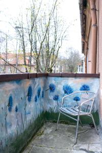 a chair sitting in front of a wall with blue flowers at Klaipeda Station Hostel in Klaipėda