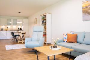 a living room with a blue couch and a table at Schöne Tiet - Küste33 26 in Tossens