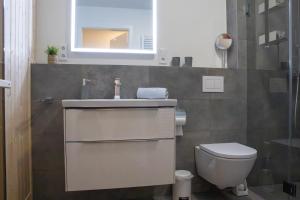 a bathroom with a toilet and a sink and a mirror at Schöne Tiet - Küste33 26 in Tossens +22 photos