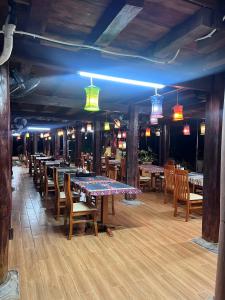 a dining room with tables and chairs and lights at Golden Mountain Hostel in Ninh Binh