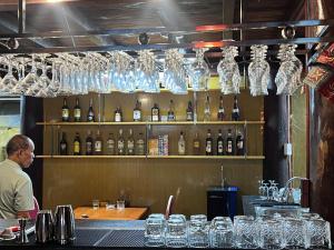 a man standing behind a bar with bottles of wine at Golden Mountain Hostel in Ninh Binh