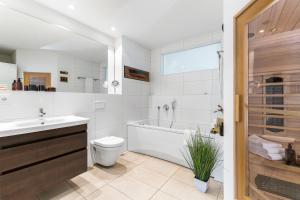 Un baño con bañera, inodoro y lavabo. en Spinnaker, en Olpenitzdorf 35 fotos más