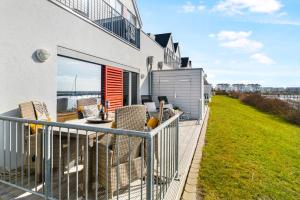 Un balcón de una casa con una mesa y sillas. en Spinnaker, en Olpenitzdorf