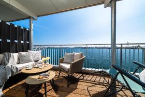 a balcony with chairs and a table and a view of the water at Admirals Cabin in Olpenitzdorf