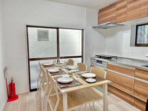a kitchen with a table and chairs in a room at Mic HANEDA in Tokyo