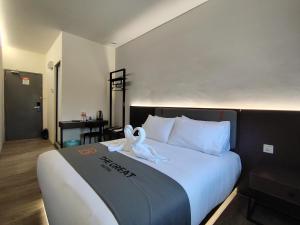 セリ・イスカンダルにあるThe Great Hotel Sri Iskandarの白鳥がベッドの上に座っている
