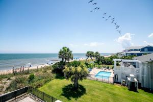 een uitzicht op het strand vanaf het balkon van een strandhuis bij Marysol Main in Edisto Beach