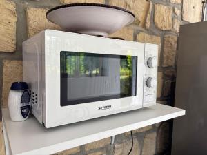 a microwave sitting on a shelf with a light at Beau Studio in Gouvieux +3 photos