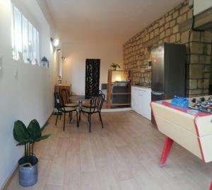 a kitchen with a table and chairs and a refrigerator at Beau Studio in Gouvieux
