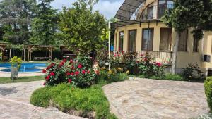 瓦尔纳Complex Maxim - sea view and free parking的游泳池前鲜花的房子