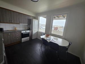 a kitchen with a table and two chairs and a window at Best flat in town in Kristiansund