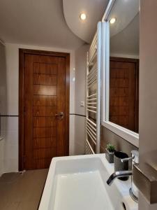 a bathroom with a sink and a wooden door at Harbour, the Unique Chania Old Town Apt in Chania Town